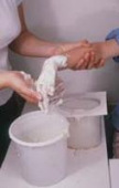 Einstreichen der Hand mit Alginatpaste vor dem Eintauchen in die Abformmasse